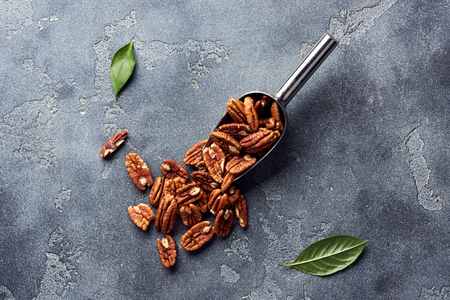 Pecan nuts and scoop on gray tableの写真素材