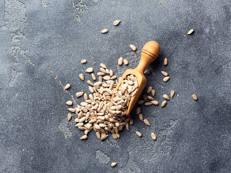 Peeled sunflower seeds with scoop on gray concrete background. Top view.の写真素材