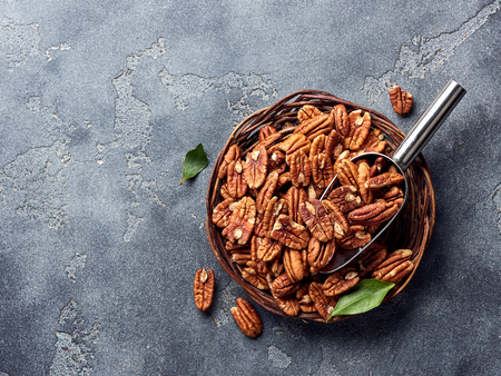 Pecan nuts and scoop on gray tableの写真素材