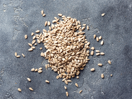 Heap of peeled sunflower seeds on gray concrete background. Top view.の写真素材