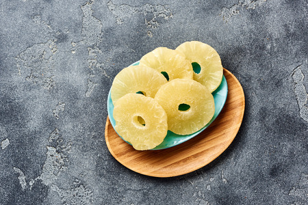 Dried pineapple rings on a gray table. Top viw of sweet paneapple slices.の写真素材