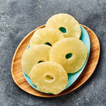 Dried pineapple rings on a gray table. Top viw of sweet paneapple slices.の写真素材