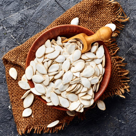 Raw pumpkin seeds on gray background. Top view.の写真素材