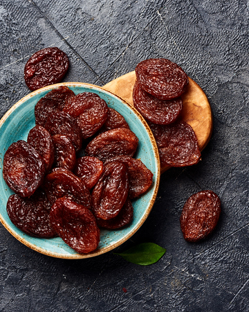 Dried brown apricots on gray background. Top view.の写真素材