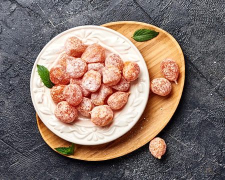 Dried sweet kumquat under powdered sugar on plate. Top view of dessert.の写真素材