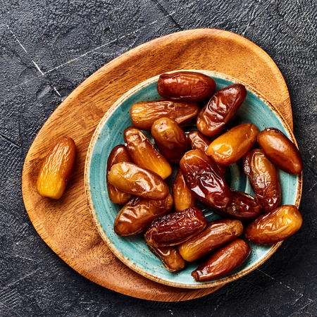 Dried dates fruits on plate. Top view of pitted dates.の写真素材