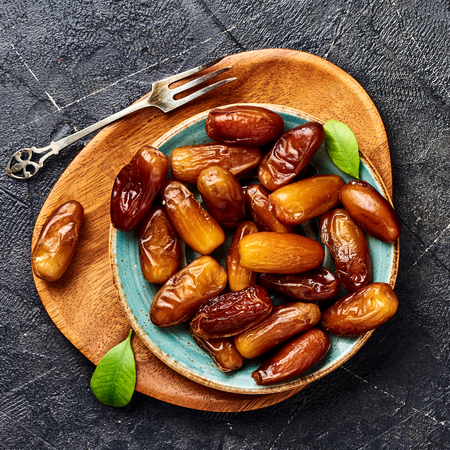Dried dates fruits on plate. Top view of pitted dates.の写真素材
