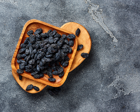 Black raisins on plate. Top view of dried grapes.の写真素材