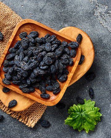 Black raisins on gray background. Top view of dried grapes.の写真素材