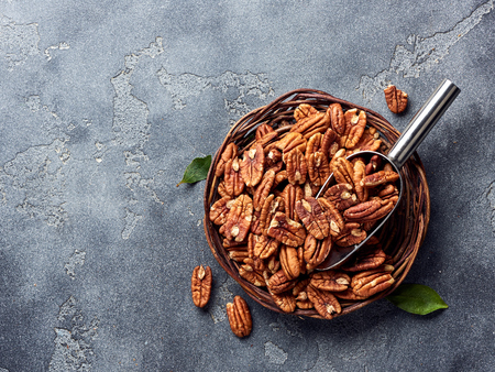 Pecan nuts and scoop on gray concrete backgroundの写真素材