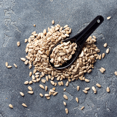 Peeled sunflower seeds on gray concrete background. Top view.の写真素材
