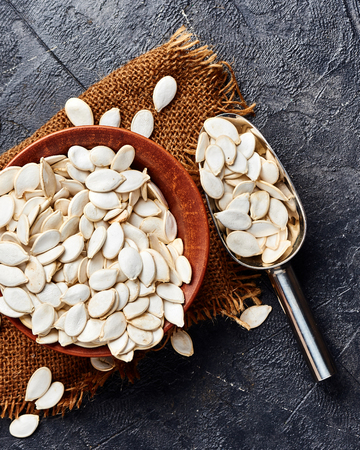 Raw pumpkin seeds on black background. Top view.の写真素材