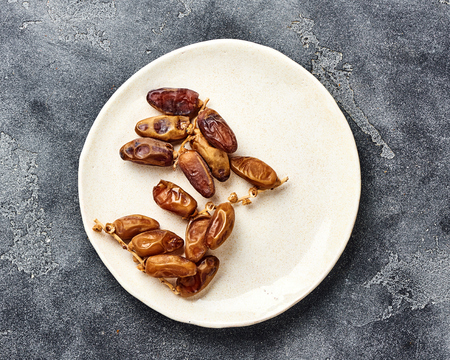 Dried dates fruits on plate with copy space. Top view.の写真素材