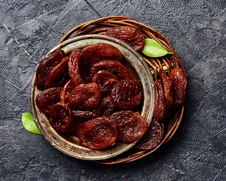 Dried brown apricots on gray background. Top view.の写真素材