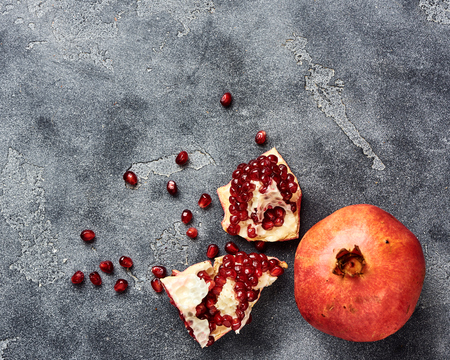 Pomegranate fruit with seeds on gray background with copy space. Top view.の写真素材