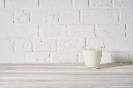 Glass of milk on white wooden background.の写真素材