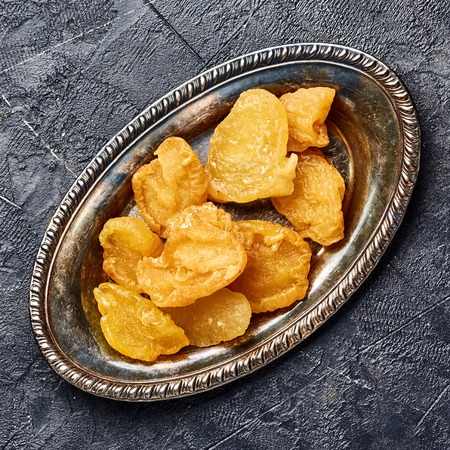 Dried pear, apricot or peach on black background. Top view of candied fruits.の写真素材