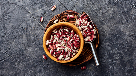 Red beans with white spots on black background. Top view.の写真素材