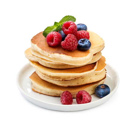 Stack of delicious pancakes with berries and mint leaf on plate isolated on white.の写真素材