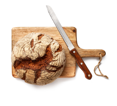 Freshly baked bread with bread knife on a wooden cutting board isolated, top view.の写真素材