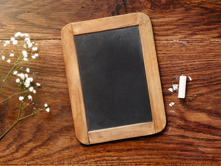 Chalk board and chalk on wooden table. Mockup for calligraphy and lettering.の写真素材