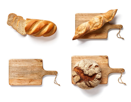 Bakery mockup. Set of baked breads on wooden cutting board isolated. Loaf and wooden board on white background. Top view.の写真素材