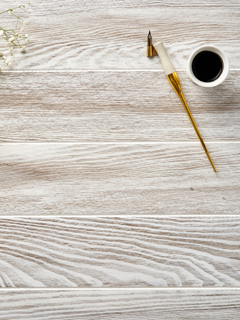 Calligraphy pen and ink on a wooden white table. View from the top.の写真素材