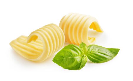 Butter curls or butter rolls with basil leaves isolated on white backgroundの写真素材