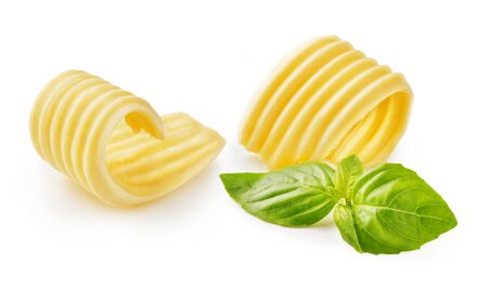 Butter curls or butter rolls with basil leaves isolated on white backgroundの写真素材
