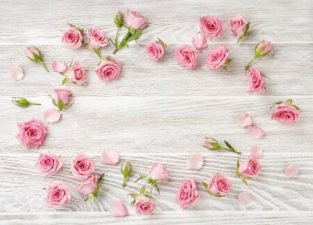 Rose flowers on white wooden background with copy space for design, text. Top view of pink roses and rosebuds.の写真素材