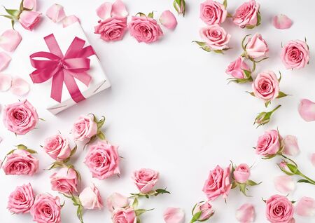 Rose flowers and gift on white background with copy space for design, text. Top view of pink roses and rosebuds. Happy Mothers Day.の写真素材