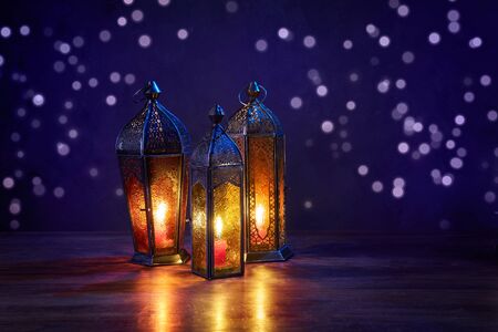 Ramadan lanterns on dark blue background. Greeting Cards for Muslim Holidays. An illuminated Arabic...