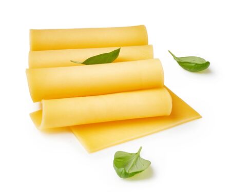 Cheese slices isolated on white background. Pieces of cheese with basil leaves.の写真素材
