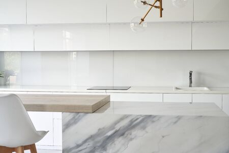 Kitchen table top and blur background of glossy kitchen interior. Minimal or scandy style.の写真素材