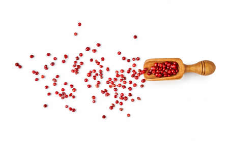 Red pepper grain with wooden scoop isolated on white background.