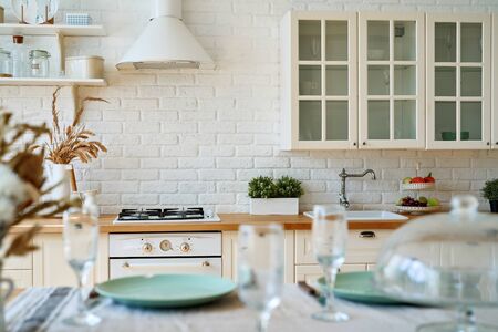 Serving for dinner on kitchen table. Light kitchen background interior.の写真素材