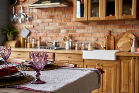 Serving for dinner on kitchen table. Warm kitchen background interior. Mockup.の写真素材