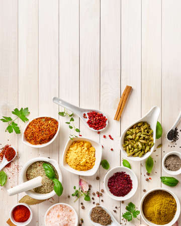 Different indian spices in a bowls and herbs on white wooden background. Top view of indian spices with copy space.の写真素材