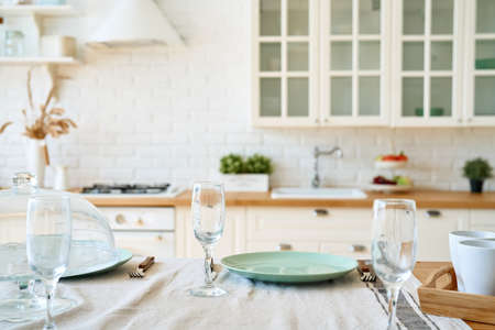 Serving for dinner on kitchen table. Light kitchen background interior.
