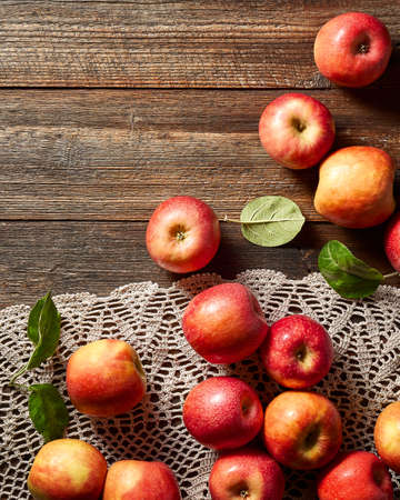 Red apple on rustic wooden table and crochet tablecloth. Summer or autumn season.の写真素材