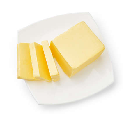 Sliced butter of piece butter on white plate isolated. Top view.の写真素材
