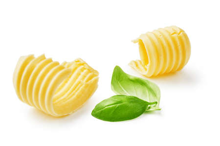 Butter curls or butter rolls with basil leaves isolated on white backgroundの写真素材