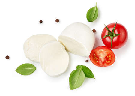 Pieces of mozzarella Buffalo cheese with basil leaves. Top view of sliced cheese with tomatoes isolated on white background.の写真素材
