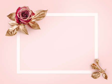 Greeting card template. Top view flat lay with copy space. Gold rose with golden leaves on pink background. Gold rose flower.の写真素材