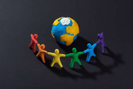Multicultural people around Earth. Justice and no racism concept. Gender and racial equality. DIY. Childrens crafts from colored plasticine. Group of people around the world.の写真素材