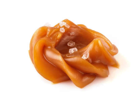 Soft caramel swirl with salt isolated on white background. Caramel sauce.の写真素材