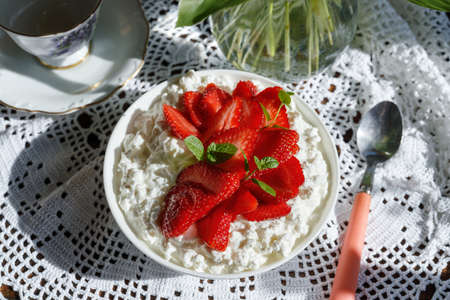 Soft cheese with strawberries in white bowl on napkin.の写真素材
