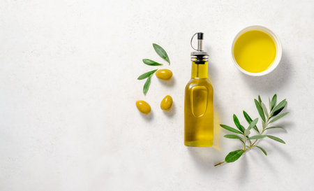 Olives and olive oil in white bowl with bottle of olive oil on white background. Mockup for package. Copy space.の写真素材