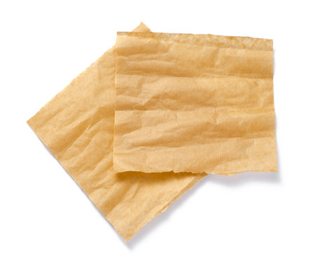 Baking paper isolated. Crumpled pieces of brown parchment or baking paper on white background. Top view. Design element.の写真素材