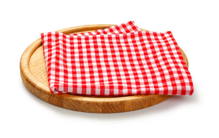 Red check napkin and board for pizza on white background. Red napkin on wooden round board isolated.の写真素材